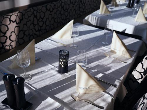 a table with wine glasses and napkins on it at Hotel Planai by Alpeffect Hotels in Schladming