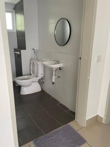 a bathroom with a toilet and a sink and a mirror at Double AS Homestay in Putrajaya