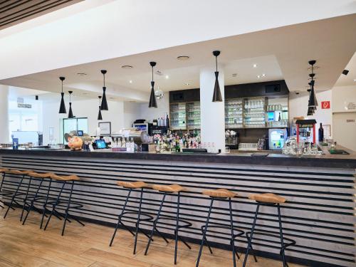 a bar at a restaurant with stools at Hotel Planai by Alpeffect Hotels in Schladming