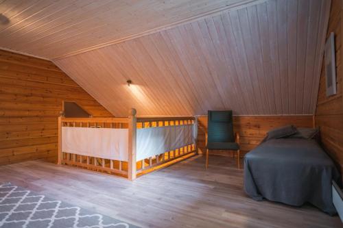 a room with a bed and a chair in a attic at Iisland Uoma waterfront house, sauna in Ii in Ii
