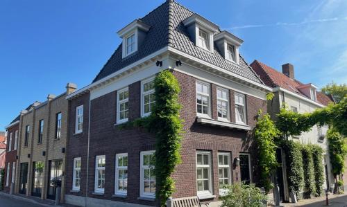 a large brick building with ivy growing on it at Boutique Hotel Nieuw Uilenburg in Den Bosch
