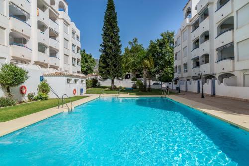 a swimming pool in front of a building at LXR Marysol II 2BDR. Apt in Benalmádena