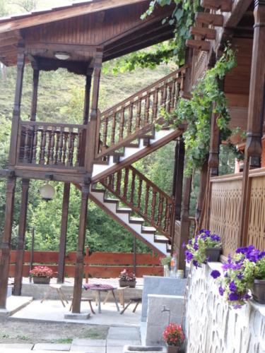 a wooden staircase leading up to a house with flowers at Недкова къща in Koprivshtitsa