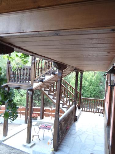 a large wooden deck with a table and a chair at Недкова къща in Koprivshtitsa