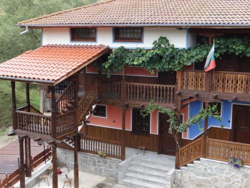 a large wooden house with a staircase in front of it at Недкова къща in Koprivshtitsa