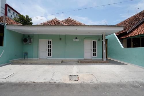 萬隆的住宿－OYO Life 91589 Bunda Homestay Syariah，白色门和红色屋顶的绿色房子
