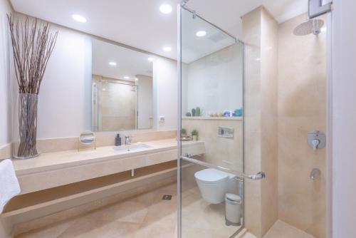 um banheiro com chuveiro, pia e vaso sanitário em High Standard 2-Bedroom in Mangroovy Residence, Pool View & Beach em Hurghada