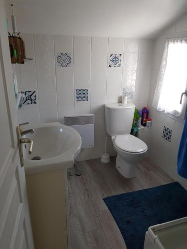 a bathroom with a toilet and a sink and a tub at Maison au calme, proche centre et mer, jardin clos in Le Croisic