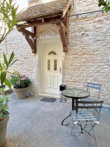 une table et deux chaises devant un bâtiment dans l'établissement Charmant studio au coeur du centre ville, à Chagny