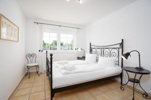 een slaapkamer met een zwart-wit bed en een raam bij Strand Domizil Wohnung 2 in Haffkrug