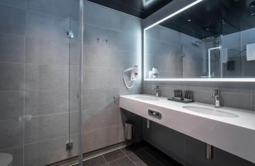 uma casa de banho com 2 lavatórios e um espelho em Thon Hotel Svolvær em Svolvær