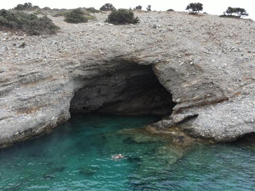 a person swimming in a cave in the water at Sarris Ligaridia Apartments in Naxos Chora