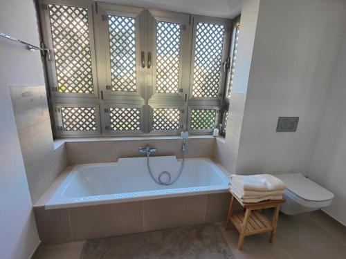 a bathroom with a bath tub and a toilet at Garden Suites luxury apartment in Palm-mar