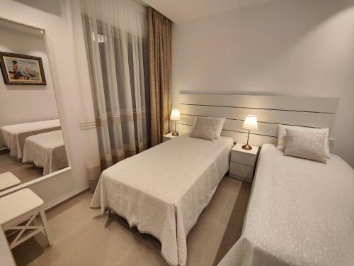 Pokój hotelowy z 2 łóżkami i lustrem w obiekcie Garden Suites luxury apartment w mieście Palm-Mar