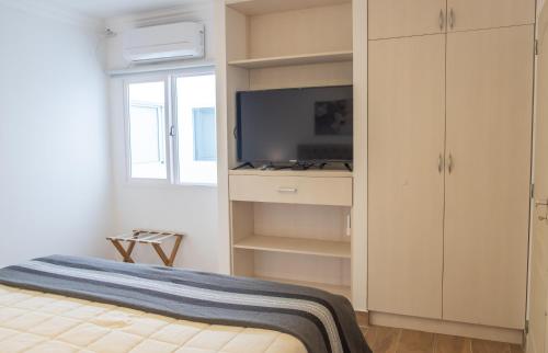 1 dormitorio con 1 cama y TV en una habitación en Augusta Deluxe en Salta