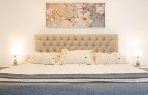 a bedroom with a large white bed with two lamps at Augusta Deluxe in Salta