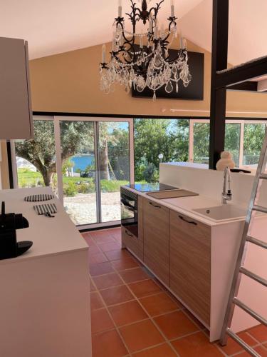 a large kitchen with a chandelier and a counter at Marti Watersports in Martinchel