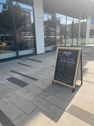 a sign on the sidewalk in front of a store at Apartments in Residence Garden Towers in Prague