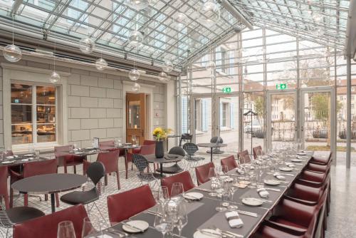 een eetkamer met tafels en stoelen en een glazen plafond bij CASPAR Swiss Quality Hotel in Muri