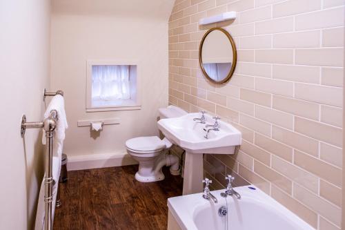 a bathroom with a sink and a toilet and a mirror at Dalmunzie Castle Hotel in Glenshee