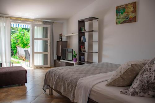 1 dormitorio con 1 cama, TV y ventana en Apartments Betty, en Rovinj
