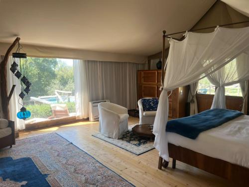 a bedroom with a canopy bed and a chair at E-glamping/Blue Saphir Tent in Arezzo