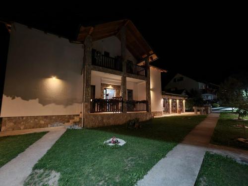 a house at night with a green yard in front at Rooms and apartmants Mirovic in Kolašin