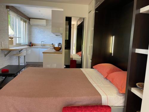 una camera con un grande letto e una cucina di Studio dans résidence privée à 15 mn de cannes a Le Cannet