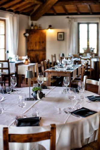 a dining room with tables and chairs with wine glasses at Il Poggio degli Olivi in Bettona