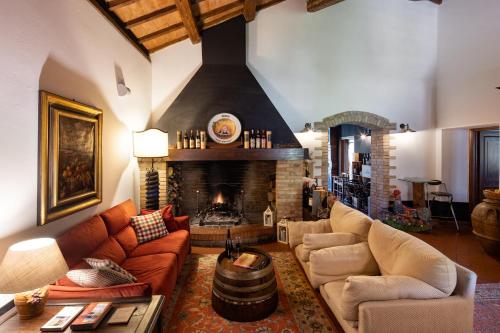 a living room with two couches and a fireplace at Il Poggio degli Olivi in Bettona