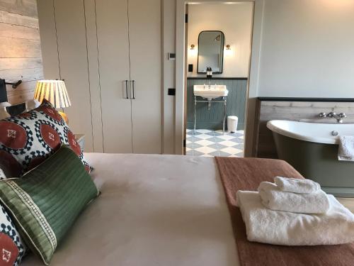 Uig Sands Rooms في Uig: غرفة نوم بسرير ومغسلة وحوض استحمام