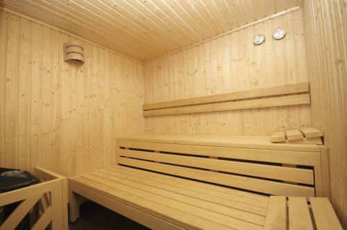 eine Holzsauna mit einer Holzbank in der Unterkunft Enzo Hotels Thionville by Kyriad Direct in Thionville