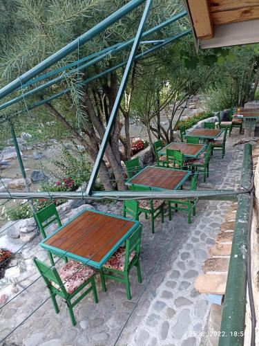 a row of green tables and benches on a patio at Rooms and apartmants Mirovic in Kolašin