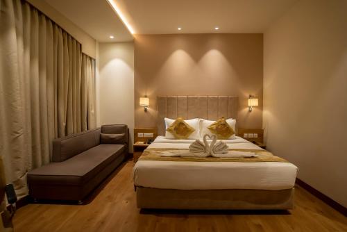 a hotel room with a bed and a couch at Celebrant Hotel in Varanasi
