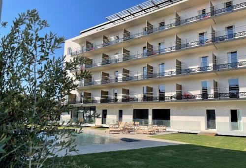 een gebouw met een zwembad ervoor bij Golden Tulip Martigues Provence in Martigues