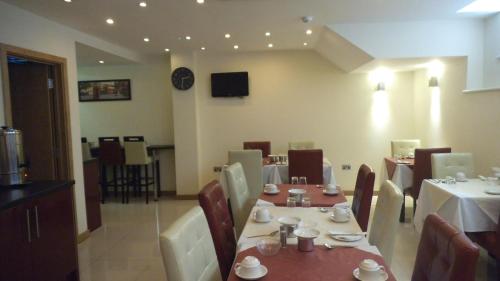 a dining room with tables and chairs in a restaurant at Regency Hotel Parkside in London