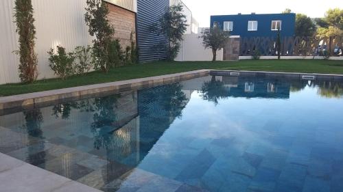 a swimming pool with blue water in a yard at Golden Tulip Martigues Provence in Martigues