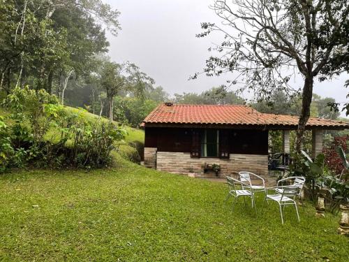 una pequeña casa con sillas delante en Chalé romântico , rústico e vista de tirar o fôlego en Guaramiranga