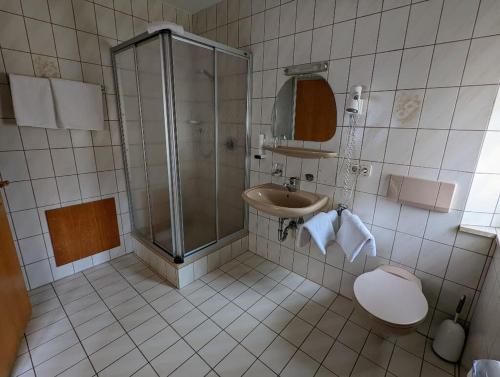 y baño con ducha, lavabo y aseo. en Cafe-Bäckerei-Pension Weigl, en Oberviechtach