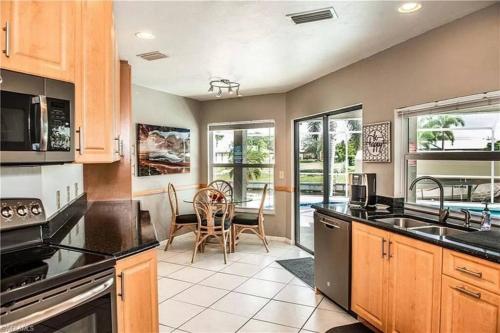a kitchen with wooden cabinets and a table with chairs at Cape Coral Water Front Paradise in Cape Coral