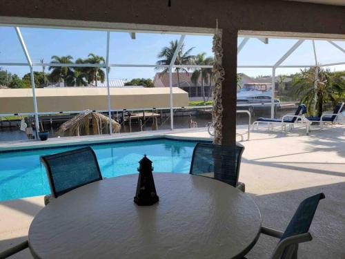 a table and chairs in front of a swimming pool at Cape Coral Water Front Paradise in Cape Coral