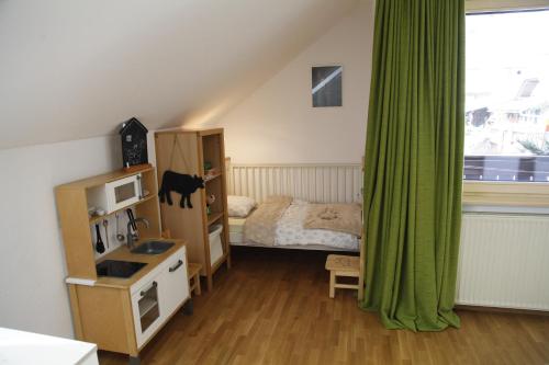 1 dormitorio con 1 cama y cortina verde en Family apartment on Repečnik farm in Gorje, Bled en Zgornje Gorje