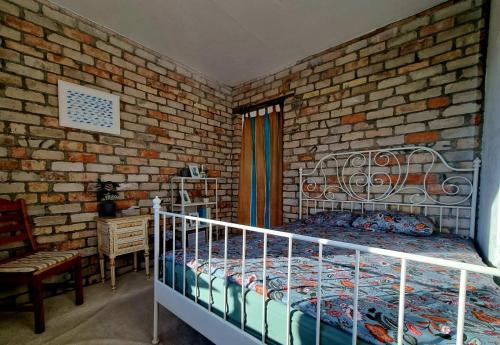 a bedroom with a bed and a brick wall at Gluosnių vila - Adutiškio pirtis in Švenčionys