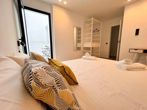a large white bed in a room with a window at La Cala de Alcalá Luxury in Alcalá