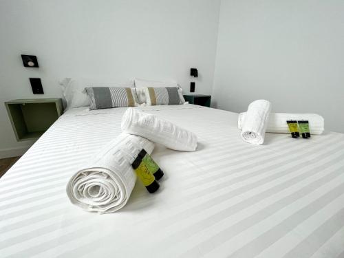 a bed with white sheets and towels on it at La Cala de Alcalá Luxury in Alcalá