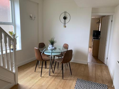 a dining room with a glass table and chairs at Modern 3 bed house in the heart of Morpeth town. in Morpeth