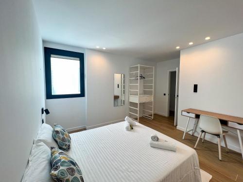 a white bedroom with a bed and a desk at La Cala de Alcalá Luxury in Alcalá