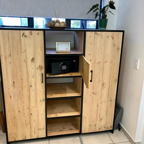 a wooden cabinet with a microwave in it at Pelican Lodge Guesthouse in Sedgefield