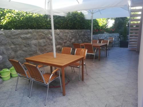 a patio with tables and chairs under an umbrella at apartmani selce in Selce