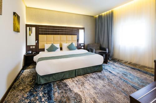 a hotel room with a large bed and a large window at White Diamond Hotel Sari in Jeddah
